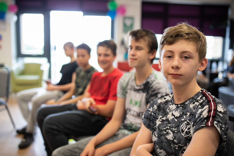 five young males sitting in a line