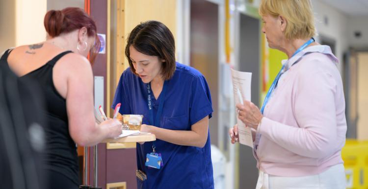Hospital staff do paper work with a patient. 