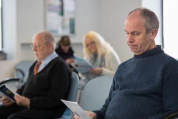 People in a GP waiting room. 