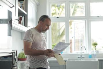 Man reads letter at home. 