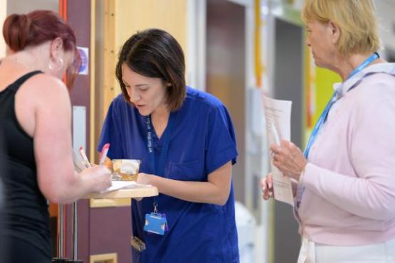 Hospital staff do paper work with a patient. 