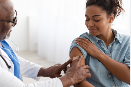 women gets vaccinated by a health care professional. 